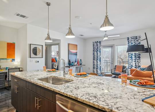A kitchen with a marble countertop and modern appliances.
