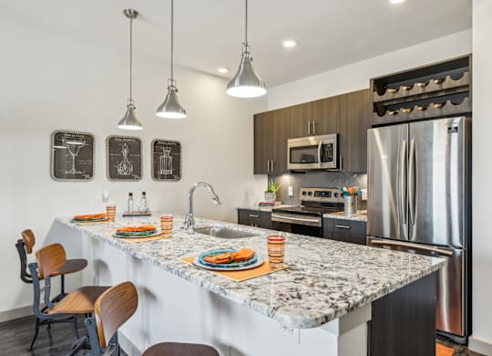 A kitchen with a marble countertop and a refrigerator.