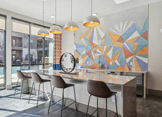 A modern kitchen with a large island and chairs.