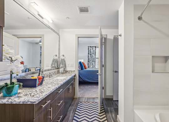 A bathroom with a white tub and a zig zag rug.
