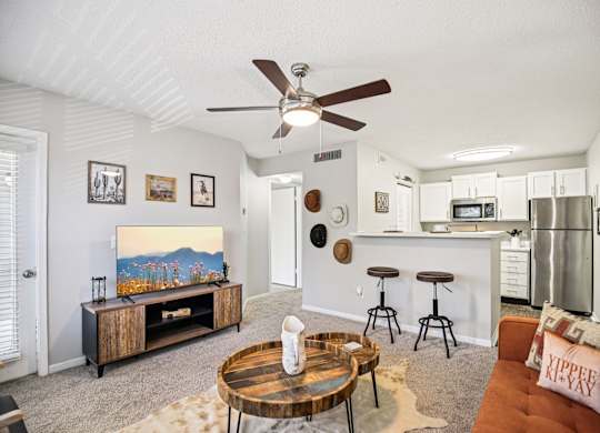A living room with a brown coffee table and a painting on the wall.