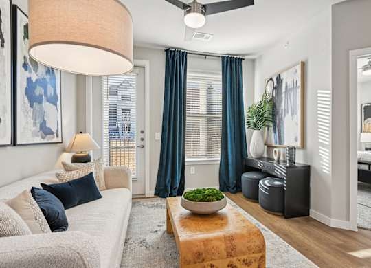 A modern living room with a large window and a ceiling fan.
