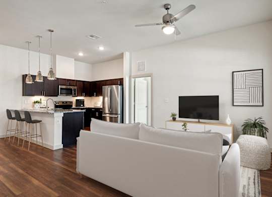 a living room and kitchen with a couch and a tv