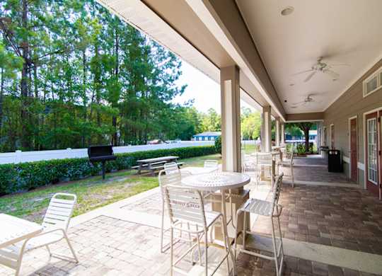 A patio with a table and chairs is covered by a roof.