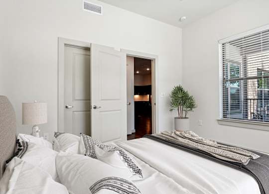 a bedroom with a large bed and a door to a bathroom
