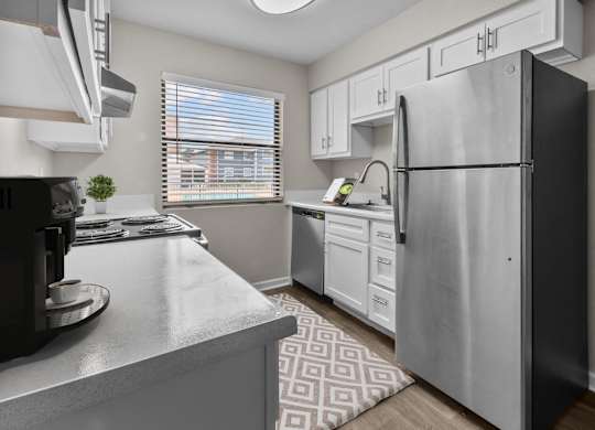 an open kitchen with stainless steel appliances and white cabinets