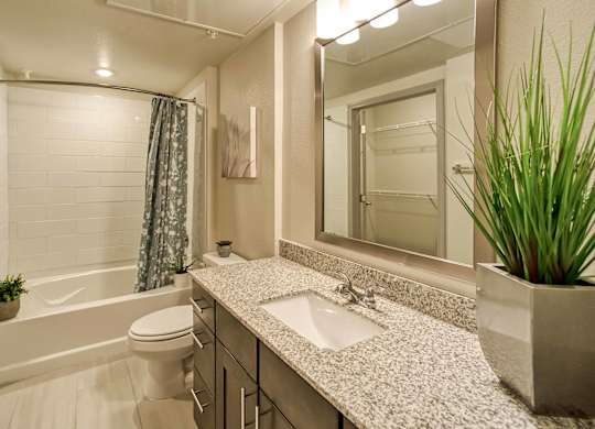 A bathroom with a white tub, sink, and toilet.