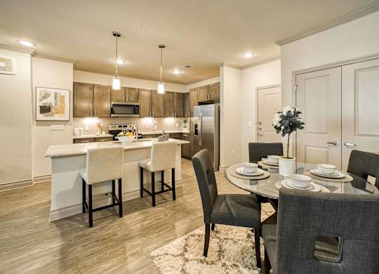 A modern kitchen with a dining table set for two.