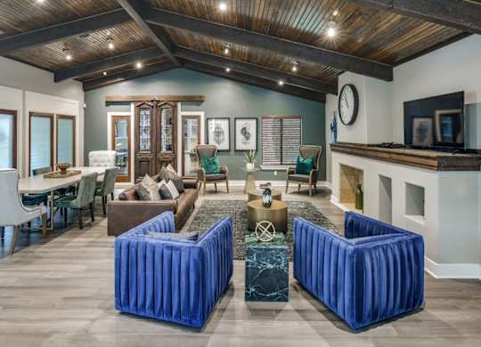 Clubhouse lounge with exposed beam ceiling, plush seating, and open gathering areas.