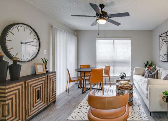 Open living area with round table, ceiling fan, and cozy seating.