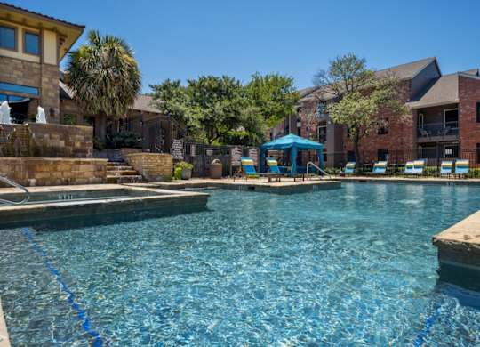 Sparkling swimming pool with shaded umbrella seating and poolside loungers.