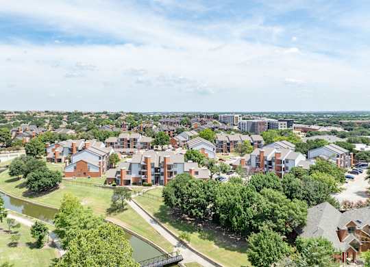 Aerial view of Heritage at Valley Ranch with pond, walking paths, and surrounding Irving neighborhood.