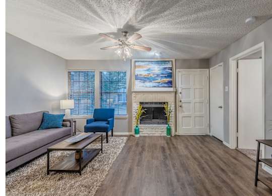 A living room with a fireplace and a painting above it.