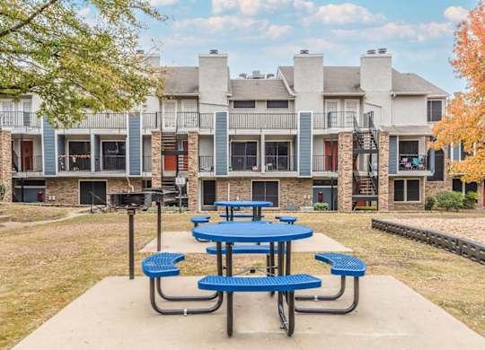 A blue picnic table is in front of a building.