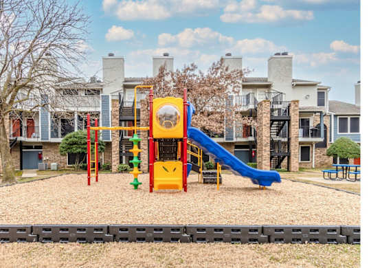 A playground with a yellow slide and a blue slide.