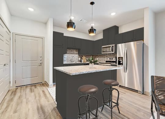 a kitchen with a bar and a stainless steel refrigerator