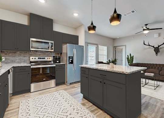 a kitchen with gray cabinets and stainless steel appliances