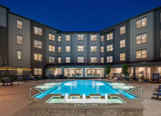 a large swimming pool in front of a building