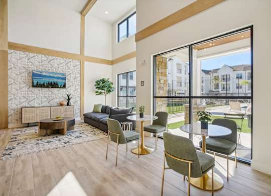 a living room with a large window and a table with chairs