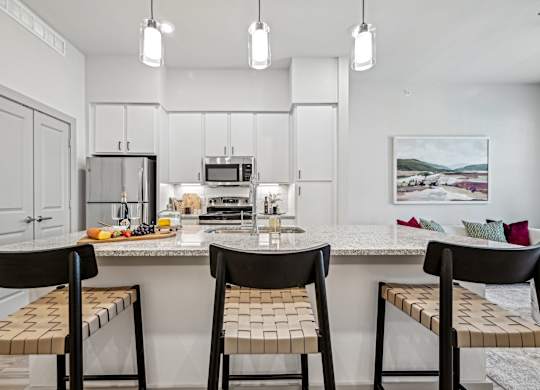 a kitchen with a marble counter top with three stools