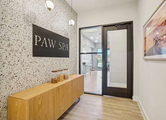 a lobby with a pay spa sign on the wall and a wooden reception desk