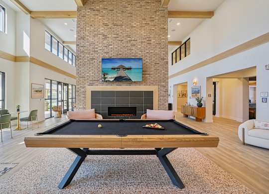 a pool table in a living room with a fireplace