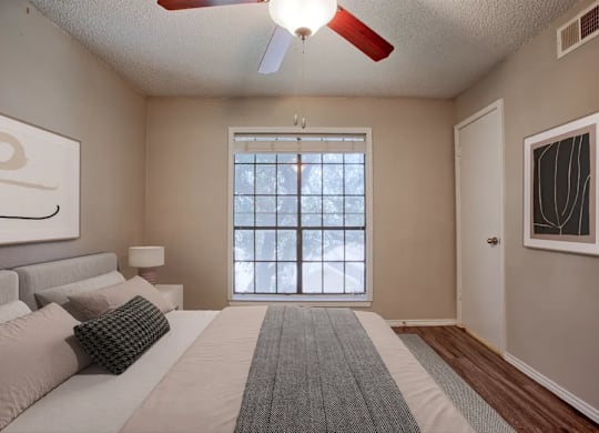 A bedroom with a large bed and a window.