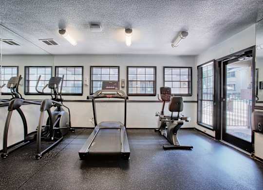 A gym with treadmills, elliptical machines, and a rowing machine.