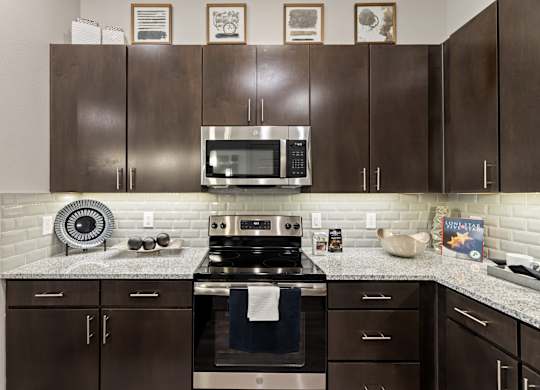A kitchen with brown cabinets and a stove top oven.