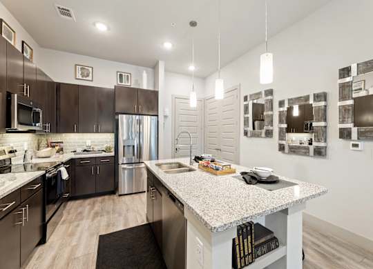 A modern kitchen with dark brown cabinets and stainless steel appliances.