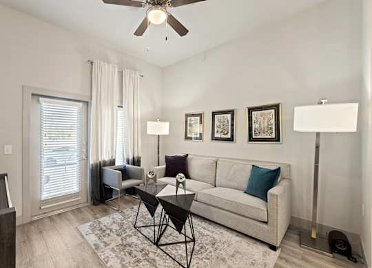 A living room with a couch, a chair, a coffee table, and pictures on the wall.