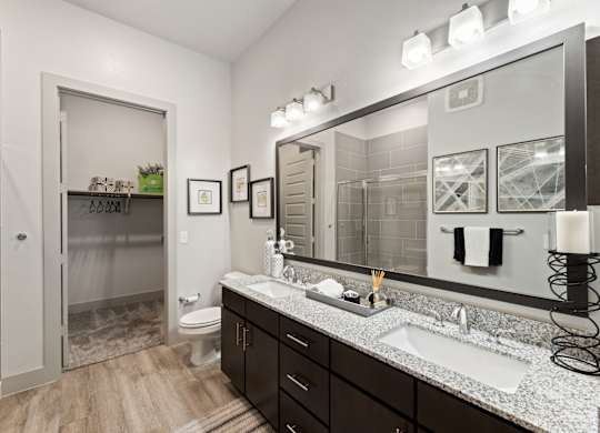 A bathroom with a sink, mirror, and toilet.