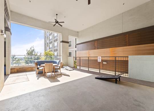 A room with a table and chairs and a fan.