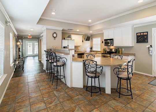 A kitchen with a bar area and chairs.