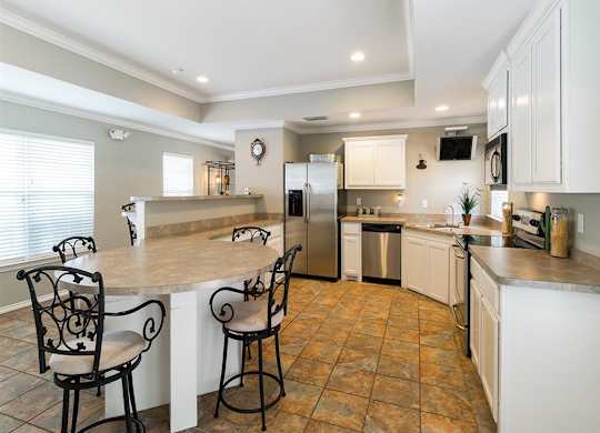 A kitchen with a tile floor and white cabinets.