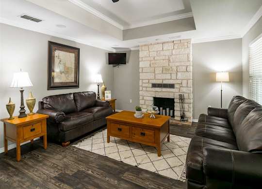 A living room with a fireplace and a painting on the wall.