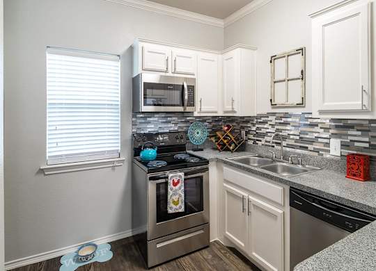 A kitchen with a stove top oven and a microwave above it.