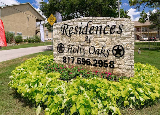 A sign for Residences at Hol Oaks with a phone number on it.