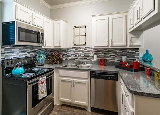 A kitchen with a black stove top oven and a black microwave.