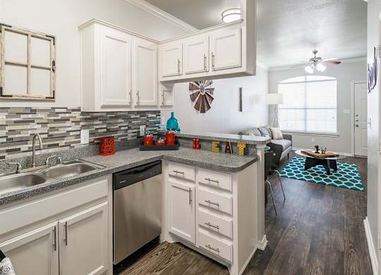 A kitchen with white cabinets and a stainless steel dishwasher.