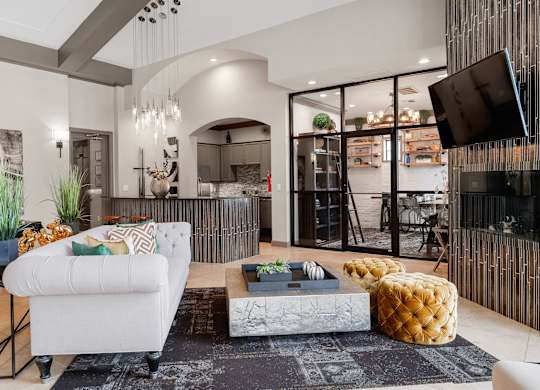 Resident lounge with fireplace, plush seating, coffee table, and adjacent glass-enclosed meeting room.