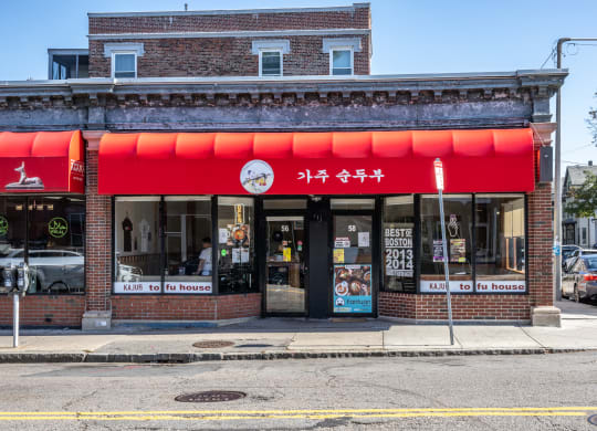 the front of a restaurant with a red facade on a city street