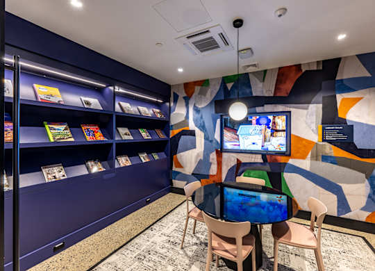A room with a blue wall and a television on a table.
