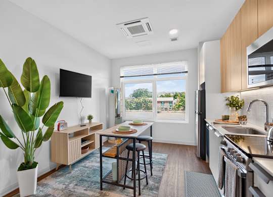 A modern kitchen with a dining table and chairs in the middle at The Indie in Allston.