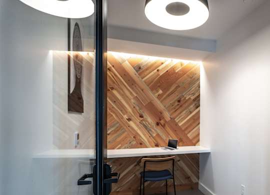 A wooden wall with a table and chair in front of it.