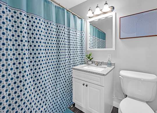 A white toilet sits next to a sink in a bathroom.