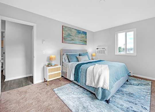 A bedroom with a large bed and a painting on the wall.