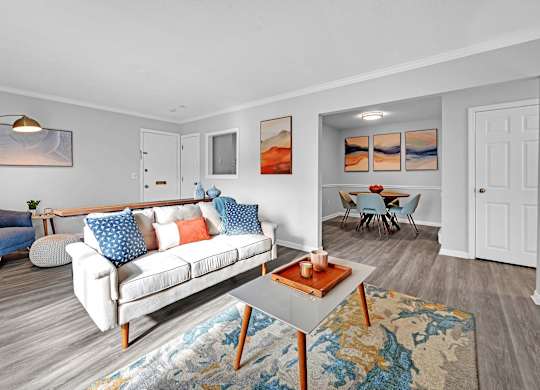 A living room with a white couch and a blue chair.