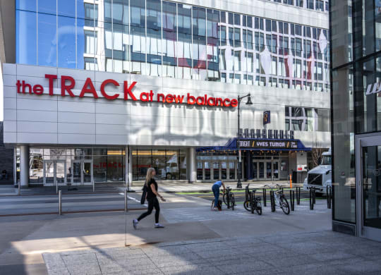 A woman walking in front of the TRACK at Boston Landing, Allston MA