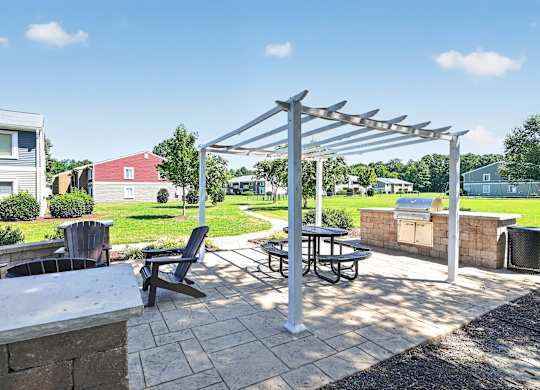 A patio with a table and chairs under a pergola.